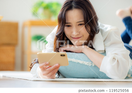 A woman is moved by watching a video on her smartphone 119525056