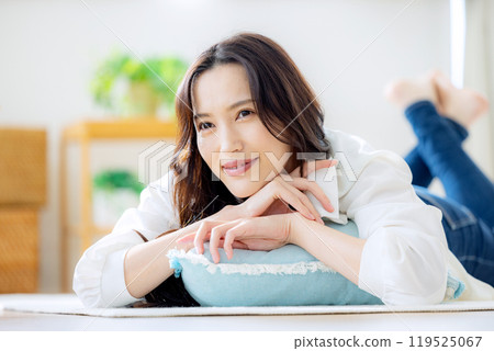 微笑的年輕女子躺在客廳裡 119525067
