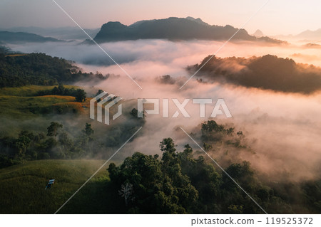 Aerial View of Morning fog and mountains as the sun rises from above Aerial View of Morning fog and mountains as the sun rises from above 119525372
