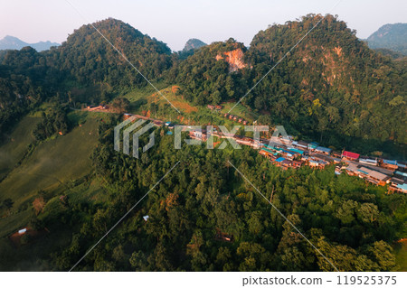 Aerial view of Morning fog and mountains with a rural village and sunrise from above 119525375