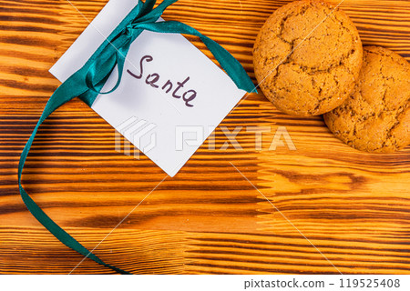 note to santa with ribbon on wooden board and cookies, christmas concept note to santa with ribbon on wooden board and cookies, christmas concept 119525408