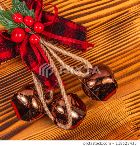 Christmas decoration bow and bells on wooden background close up Christmas decoration bow and bells on wooden background close up 119525433