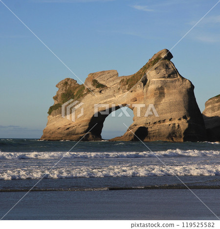 Big rock arch and waves at Wharariki Beach, New Zealand. Big rock arch and waves at Wharariki Beach, New Zealand. 119525582