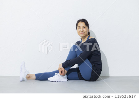 A woman in her 50s stretching 119525617