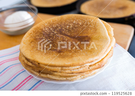Process of baking pancakes in pans on kitchen stove. stack of hot pancakes Process of baking pancakes in pans on kitchen stove. stack of hot pancakes 119525628