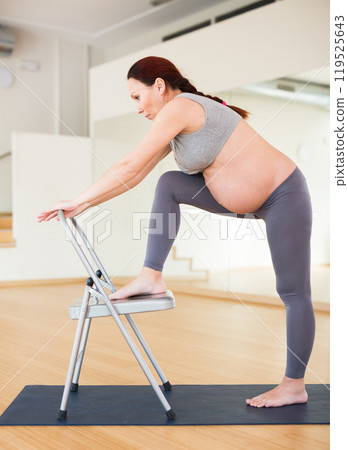Pregnant woman is engaged in yoga. Yoga exercises for legs, buttocks and thighs for a lift Pregnant woman is engaged in yoga. Yoga exercises for legs, buttocks and thighs for a lift 119525643