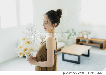 Woman holding a bouquet in the living room 119525665