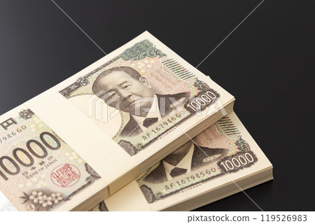 A stack of 10,000 yen bills on a black background A stack of 10,000 yen bills on a black background 119526983