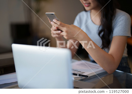 Asian teenage student woman using smartphone to chatting with friends and doing assignment homework after watching lecture video online lesson on laptop and studying about education knowledge in cafe Asian teenage student woman using smartphone to chatting with friends and doing assignment homework after watching lecture video online lesson on laptop and studying about education knowledge in cafe 119527000