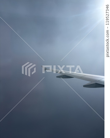 Wing of an Aircraft Soaring Through the Cloudy Sky During a Flight in the Afternoon 119527346