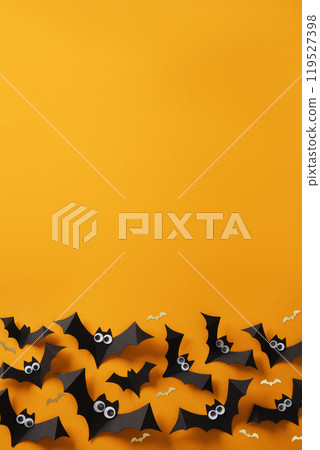 Halloween background with black paper bats and google eyes on an orange backdrop. Place for your text, invitation, advert. 119527398