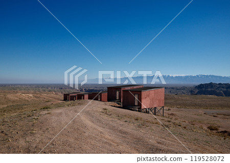 Isolated desert lodging: Modern wooden structures on hillside with panoramic views Isolated desert lodging: Modern wooden structures on hillside with panoramic views 119528072