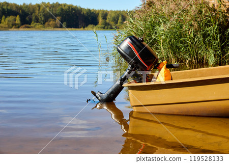 Tranquil Lake Scene with Moored Boat and Motor Tranquil Lake Scene with Moored Boat and Motor 119528133