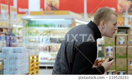 Merchandiser conducts inventory checks on a crowded supermarket shelf, providing customers with efficient and organized service Merchandiser conducts inventory checks on a crowded supermarket shelf, providing customers with efficient and organized service 119528281