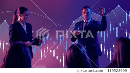 Young man, with assistant, in formal wear, speaker explains rise and fall of data points, highlighting crucial numbers. Young man, with assistant, in formal wear, speaker explains rise and fall of data points, highlighting crucial numbers. 119528609