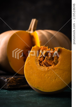 Raw fresh cut pumpkin on dark background Raw fresh cut pumpkin on dark background 119528646