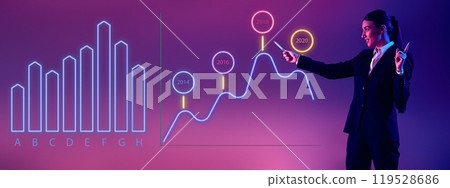 Young woman, speaker illustrates advanced data patterns on glowing screen during business seminar. Young woman, speaker illustrates advanced data patterns on glowing screen during business seminar. 119528686