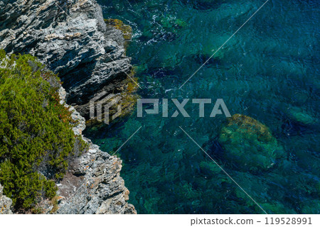 Porquerolles rugged cliffs meet the clear Mediterranean, Provence, France Porquerolles rugged cliffs meet the clear Mediterranean, Provence, France 119528991