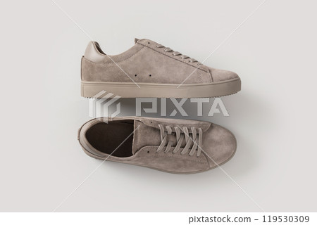 Leather nubuck gray men's sneakers on light gray background. Flat lay. View from above. Copy space. Men's sports casual shoes. Fashionable sneakers. Leather nubuck gray men's sneakers on light gray background. Flat lay. View from above. Copy space. Men's sports casual shoes. Fashionable sneakers. 119530309