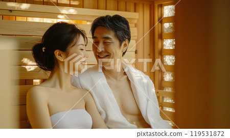 Relaxed asian couple enjoying sauna serenity in warm wooden interior 119531872