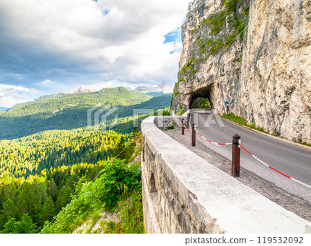 Alpine asphalt road with tunnel. Forest mountain landscape near Cortina d'Ampezzo. Dolomites, Italy. Alpine asphalt road with tunnel. Forest mountain landscape near Cortina d'Ampezzo. Dolomites, Italy. 119532092