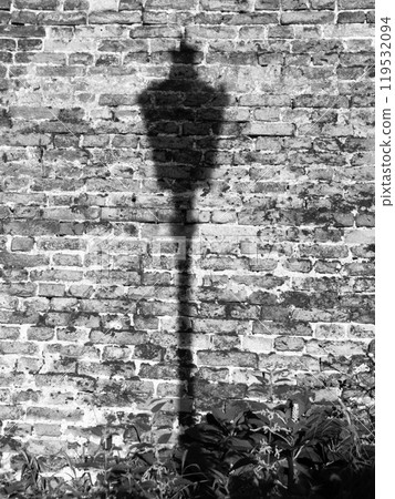 Lamp post shadow on the brick wall. Old Town of Prague, Czech Republic. Black and white image. Lamp post shadow on the brick wall. Old Town of Prague, Czech Republic. Black and white image. 119532094