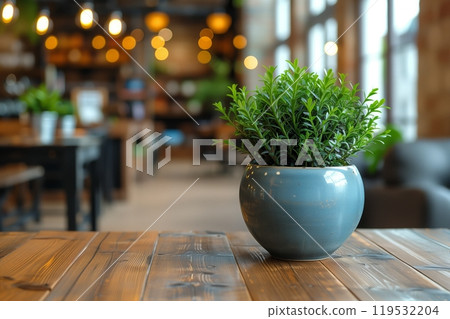 Green artificial plant in a blue pot on a cafe table in soft focus background 119532204