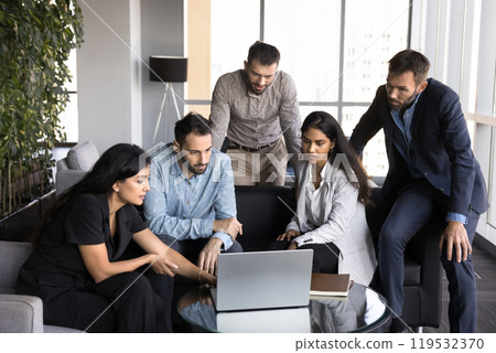 Diverse business team of young project managers working at laptop Diverse business team of young project managers working at laptop 119532370