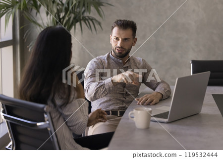 Two diverse business professional man and woman talking at workplace Two diverse business professional man and woman talking at workplace 119532444