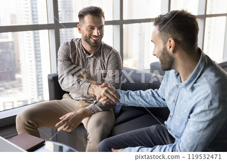 Positive confident business man giving handshake to male colleague 119532471
