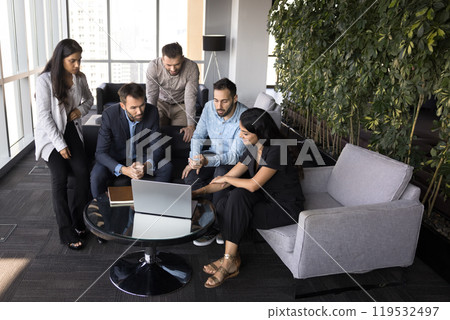 Team of young colleagues meeting at laptop in co-working space Team of young colleagues meeting at laptop in co-working space 119532497