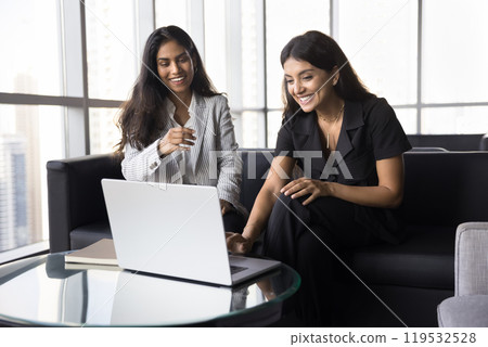 Two cheerful young multiethnic professional woman enjoying teamwork 119532528