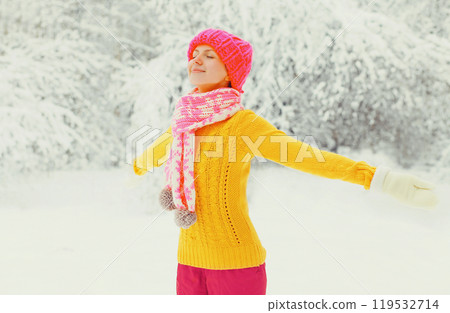 winter happy woman wear colorful hat, sweater, scarf enjoys in snowy forest or park background 119532714