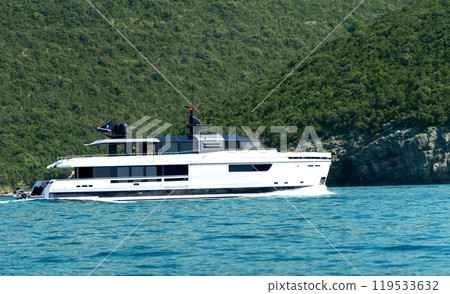 Big yacht or boat in bright blue sea against green cliff Big yacht or boat in bright blue sea against green cliff 119533632