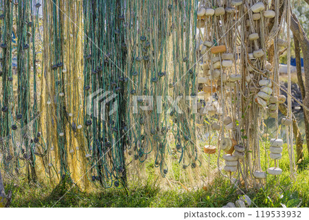 Close-up of old fishing nets with floats hanging in sunlight 119533932