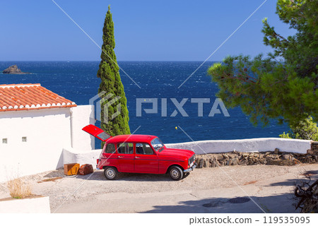 Red retro car with open trunk and luggage against the background of the sea in Cadaques Red retro car with open trunk and luggage against the background of the sea in Cadaques 119535095