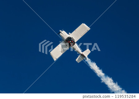 Stunt aerobatic plane performing stunts in air Stunt aerobatic plane performing stunts in air 119535284
