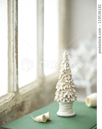 Old books and Christmas accessories placed on an antique windowsill 119536182