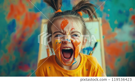 Joyful Childhood: A Humorous Young Girl Covered In Vibrant Paints And Messy Brushes, Happily Shouting With Childlike Imagination Beside An Easel. 119536423