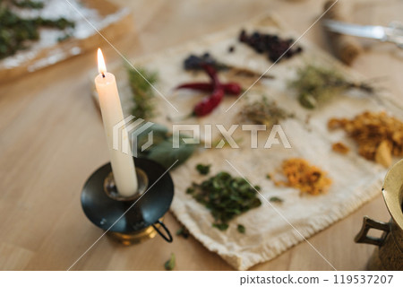 Candle on an old metal stand. Preparing nutritional supplements to improve human immunity and health. Dried herbs and seasonings. Candle on an old metal stand. Preparing nutritional supplements to improve human immunity and health. Dried herbs and seasonings. 119537207