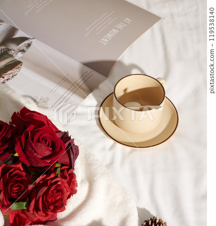 Red roses and coffee cup on white bed sheet. Minimalist lifestyle style flowers and notebook 119538140
