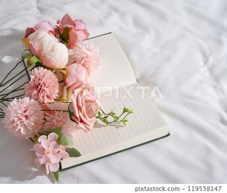 Simple still life arrangement of romantic flowers and notebook 119538147