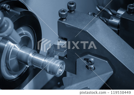 Close up scene the CNC lathe machine swiss type slot cutting at the end of brass pipe coupling parts in the light blue scene. Close up scene the CNC lathe machine swiss type slot cutting at the end of brass pipe coupling parts in the light blue scene. 119538449