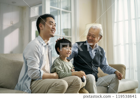 asian son father grandfather watching soccer game on TV together at home asian son father grandfather watching soccer game on TV together at home 119538641