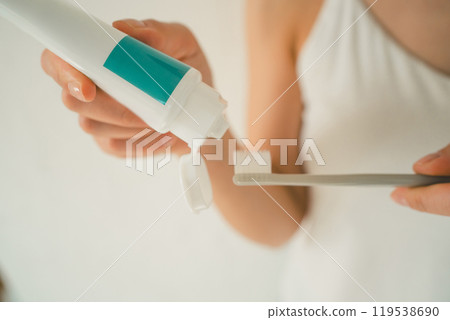 Young woman applying toothpaste 119538690