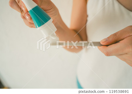 Young woman applying toothpaste Young woman applying toothpaste 119538691