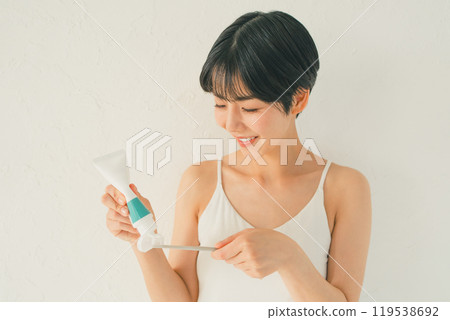 Young woman applying toothpaste 119538692