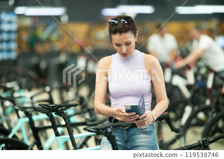 Adult woman photographing bicycle in store Adult woman photographing bicycle in store 119538746
