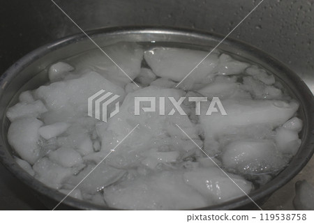 Cloudy ice in a stainless steel bowl in the sink 119538758