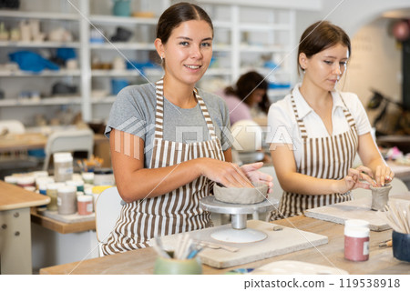 Woman teacher and student sculpt ceramic products 119538918